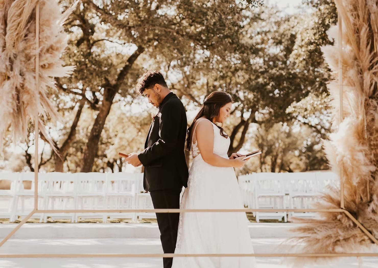 Bride and groom back to back reading letters