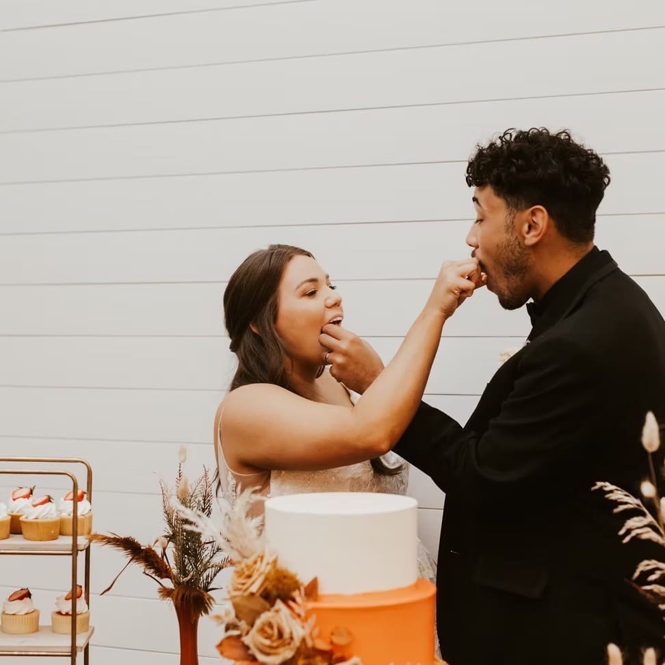 Bride and groom feeding each other cake