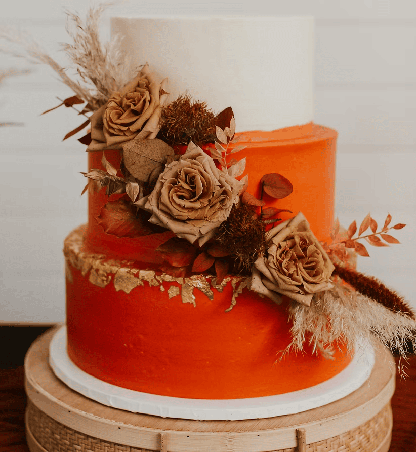 Wedding cake with muted florals and orange layers