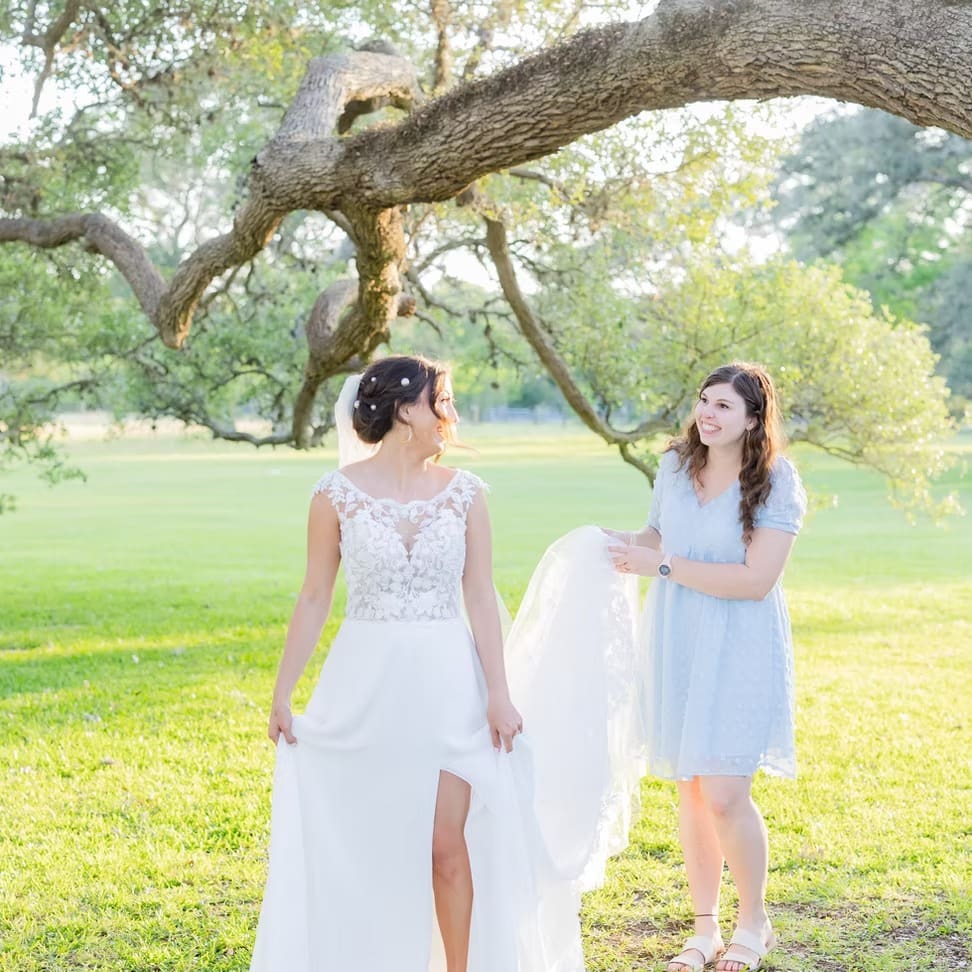 Wedding planner holding bride's train